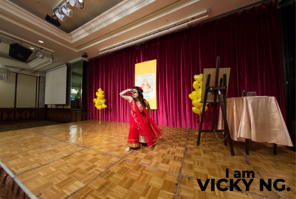 Vicky Ng performing an Indian-inspired dance on stage, representing her passion for creative storytelling and artistic expression.